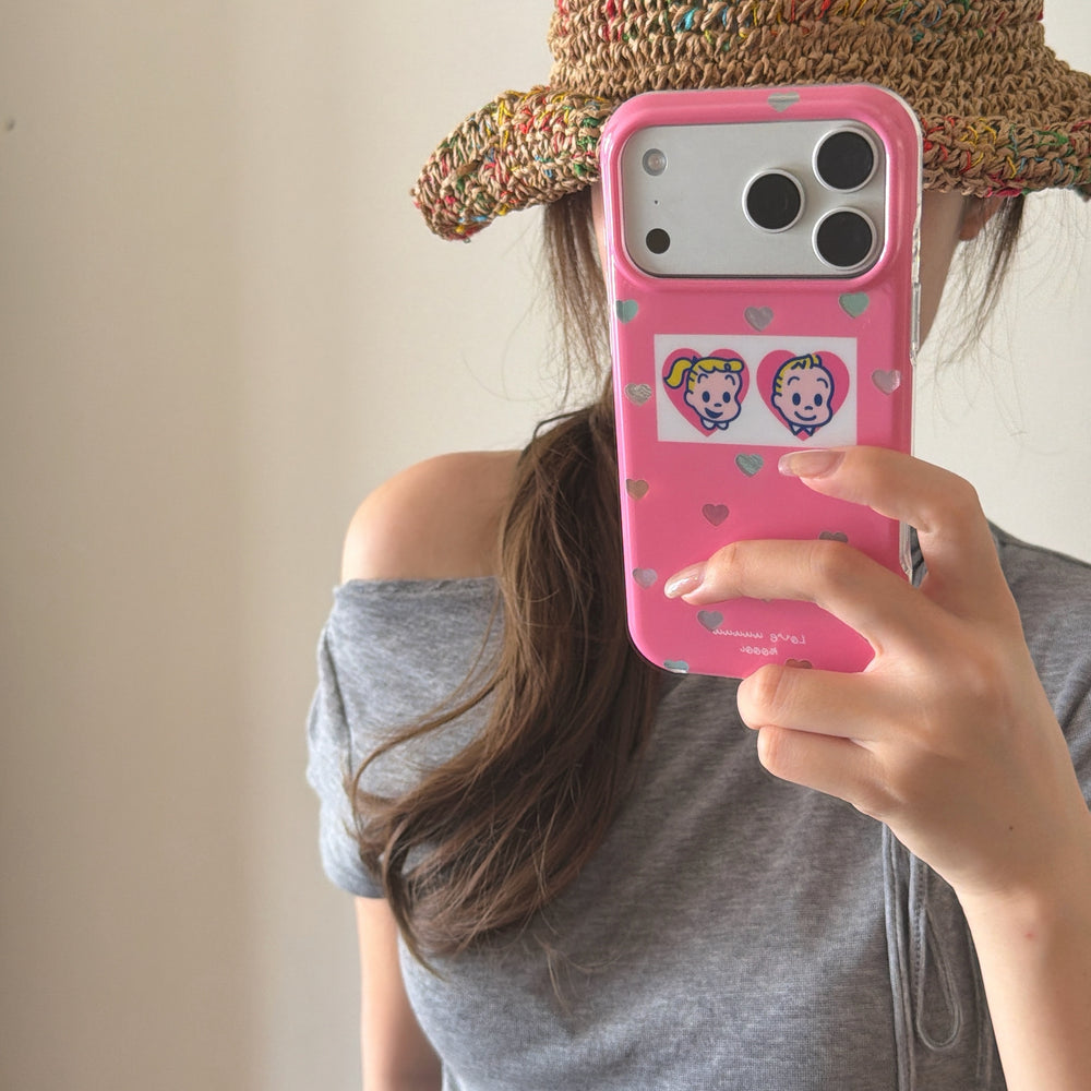 A woman taking a mirror selfie using a kawaii pink heart phone case while wearing a straw hat.