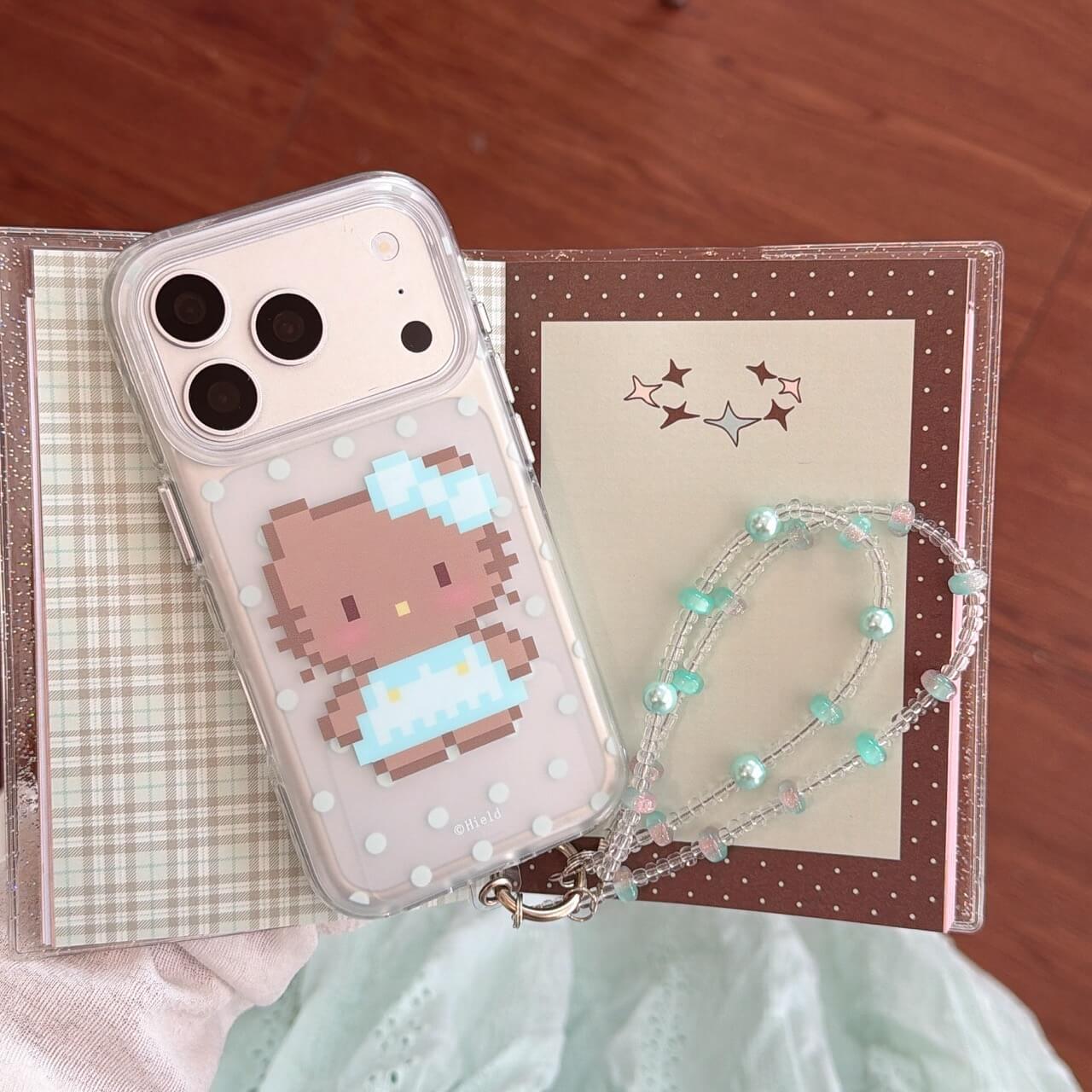 Kawaii pixel kitty iPhone case with polka dots displayed on a journal