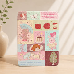 Kawaii teddy bear patchwork iPad case standing upright on a light wooden desk next to a white ceramic vase with green leaves.