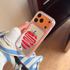 An angled shot of a kawaii tomato themed mirror phone case featuring clear protective bumper edges.