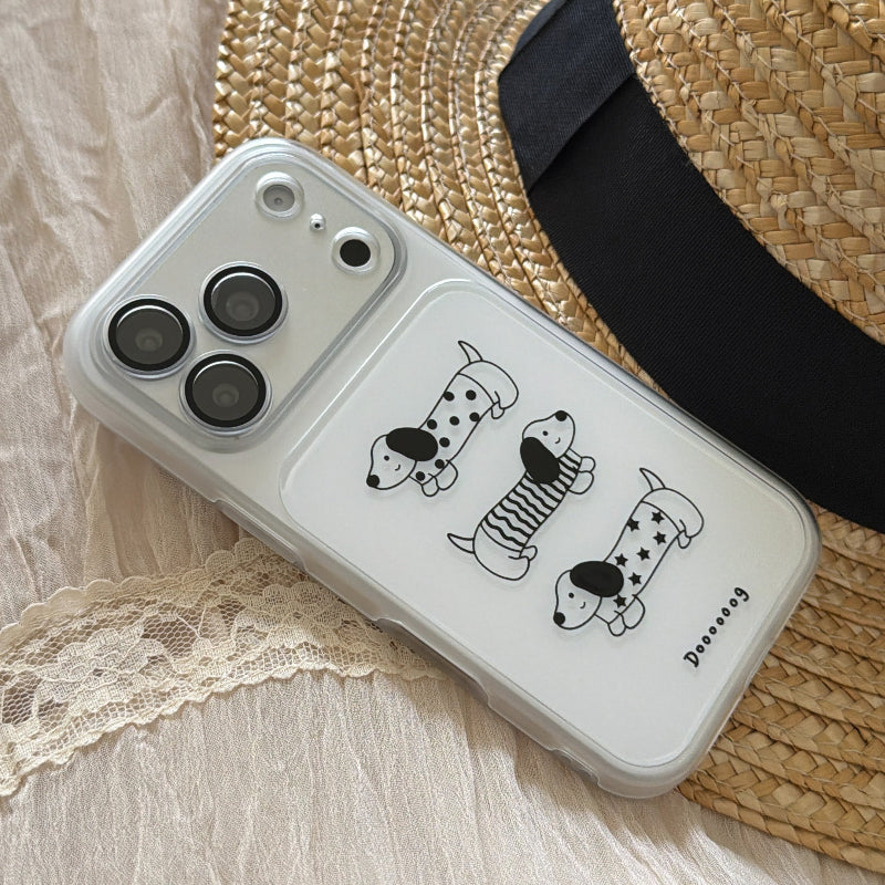 A kawaii clear wiener dog iPhone case resting diagonally against a straw sun hat.