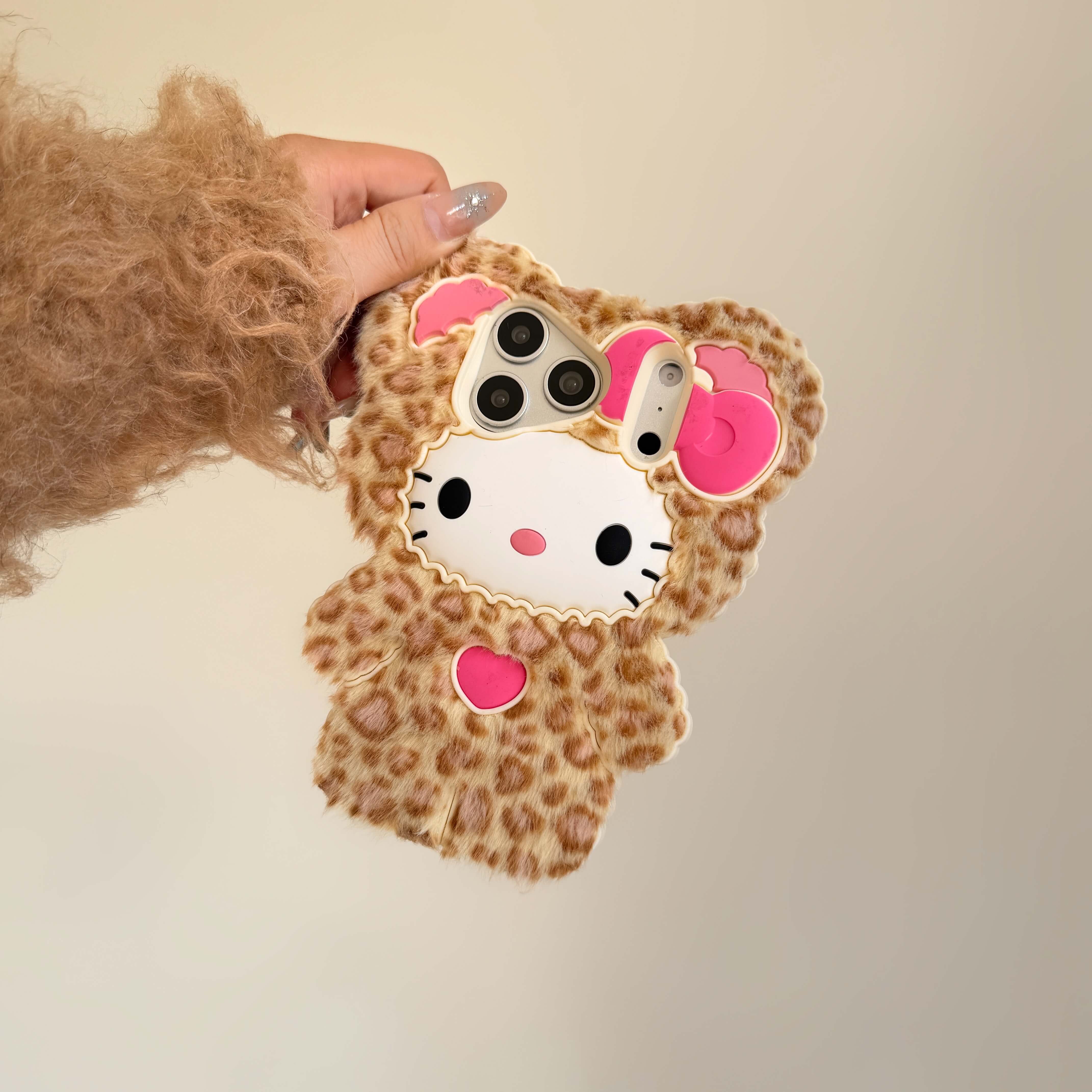 Leopard kitty plush iPhone case with a pink bow against a neutral background