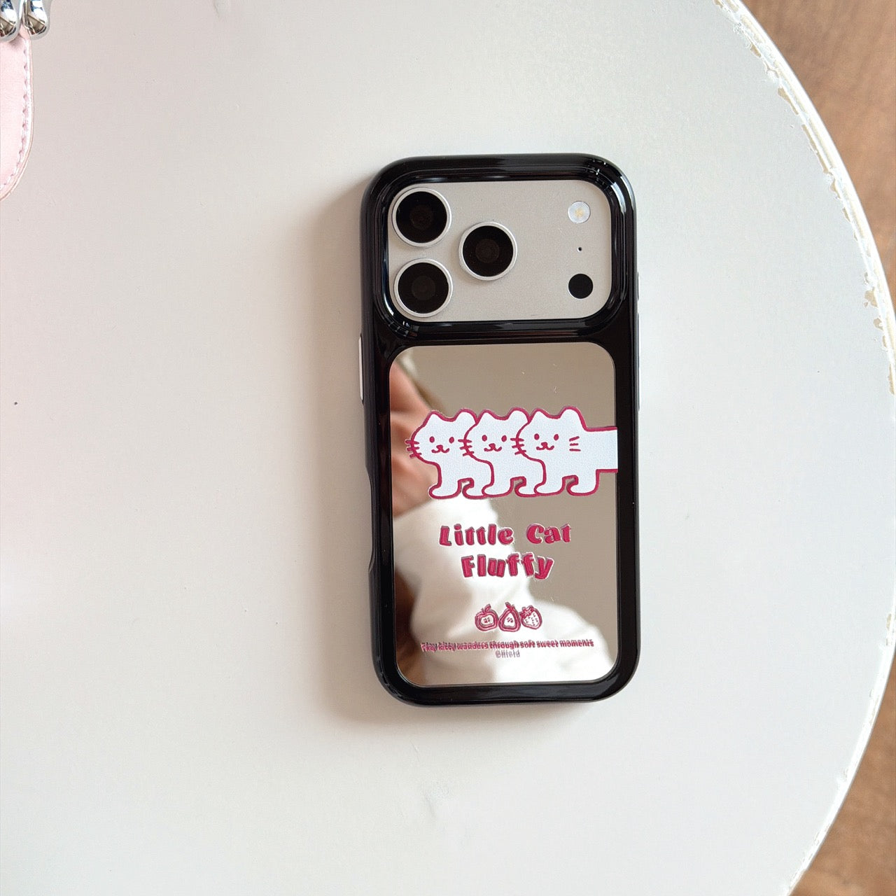 Product isolate view of the little cat fluffy mirror iPhone case with shockproof black camera ring and bezel.