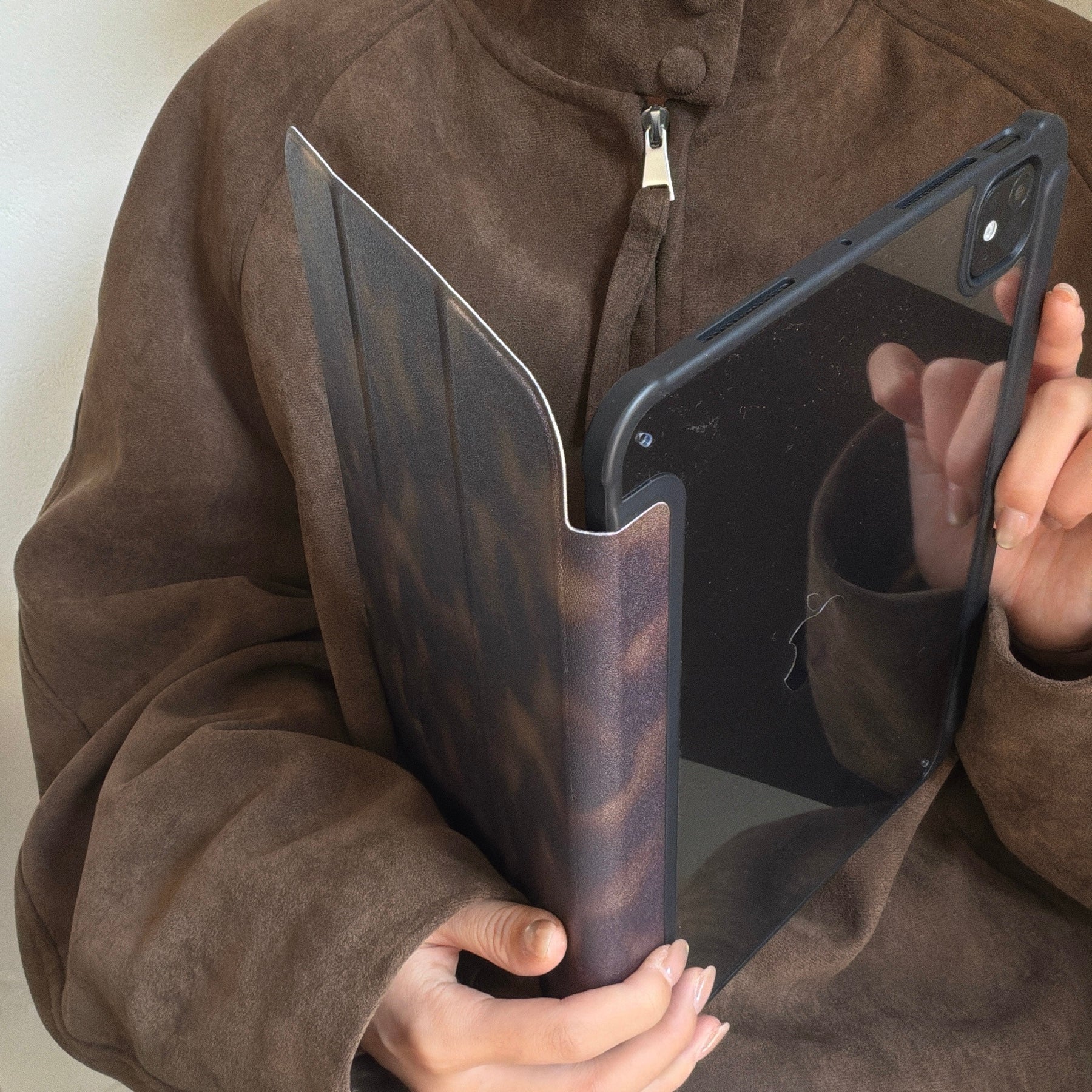 Demonstration of a magnetic detachable ipad case being pulled apart, showing how the tortoiseshell folio cover easily separates from the clear protective back shell.