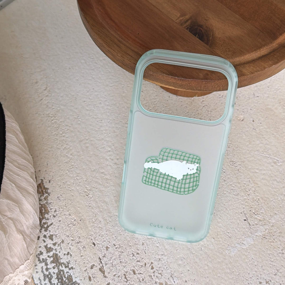 A minimalist clear couch cat iPhone case resting on a textured concrete floor under a wooden stand.