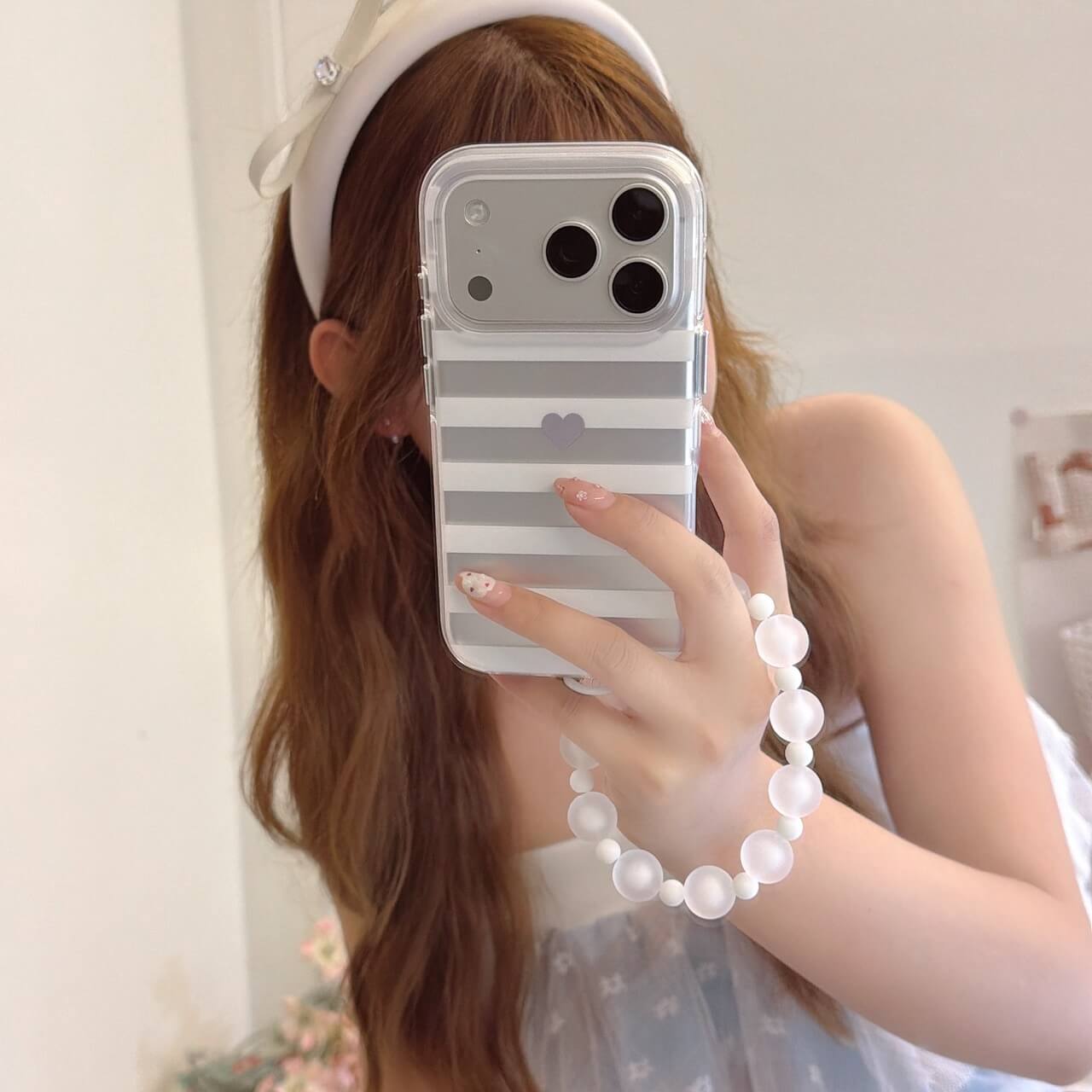 Mirror selfie with gray striped heart iPhone case and white bead strap