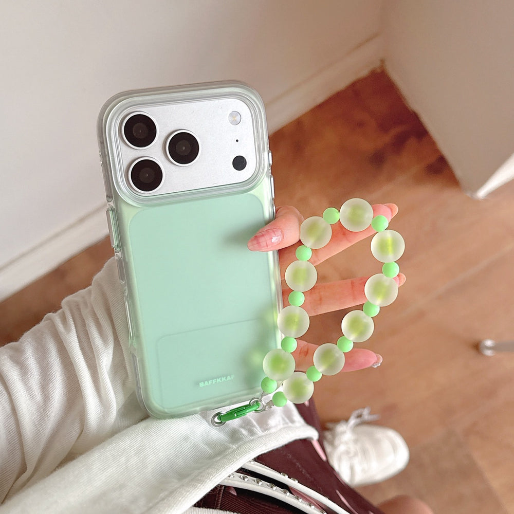 Close-up of a mint green BAFFKKAF phone case with a shockproof clear bumper and a green beaded bracelet holder.
