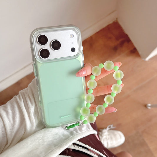 Close-up of a mint green BAFFKKAF phone case with a shockproof clear bumper and a green beaded bracelet holder.