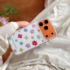 A woman holding an orange accent dopamine flower iPhone case over a white ruffled dress.