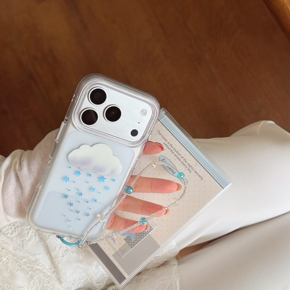 A person holding the orange camera plate cloud and star phone case with a floral background.
