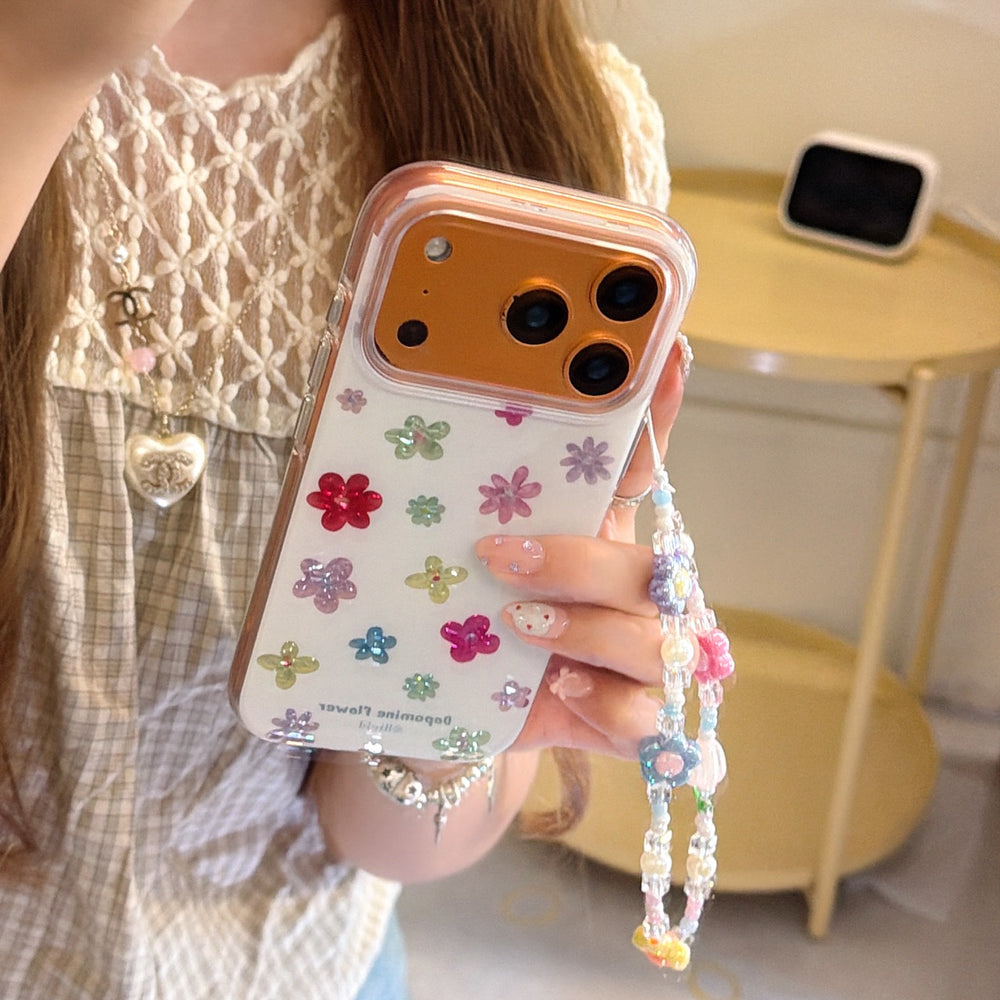 Close-up of a person holding an orange camera frame floral phone case with a colorful Y2K beaded charm.