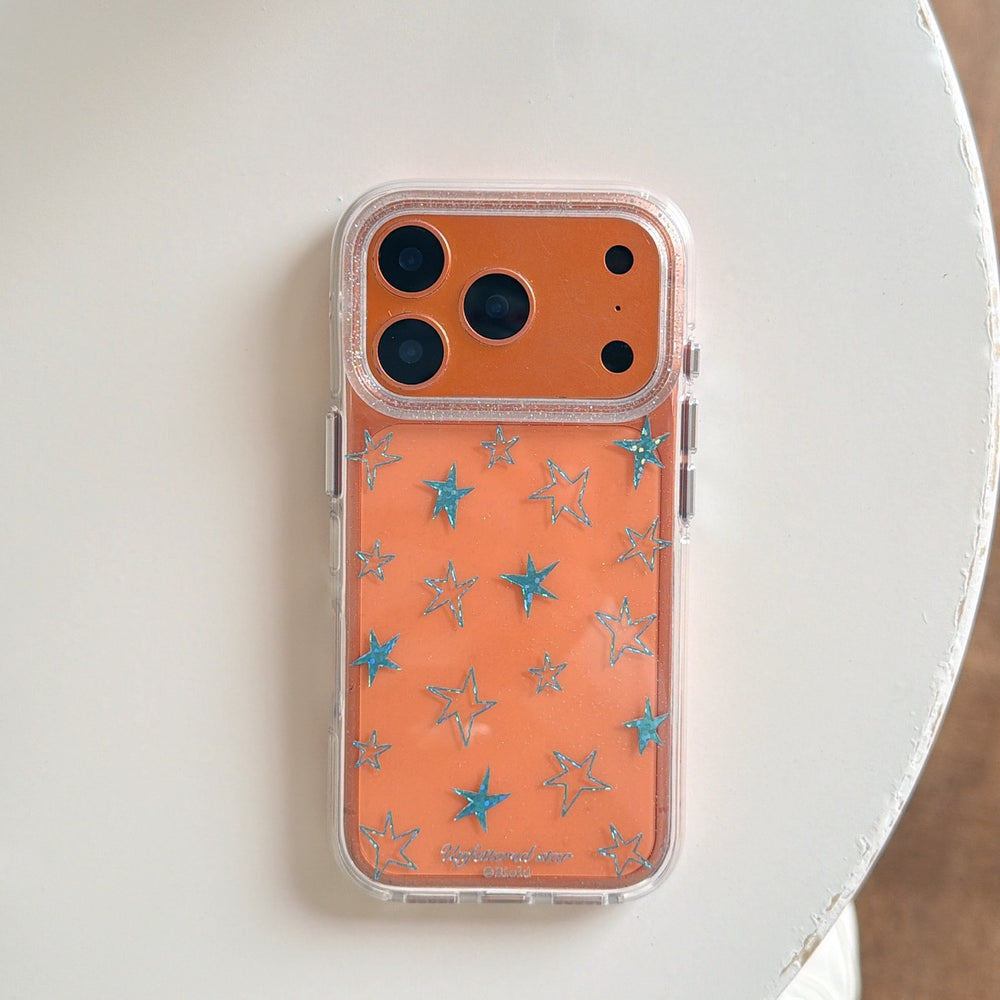 Flat lay of an orange Y2K star clear phone case isolated on a white surface.