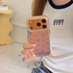 A hand holding an orange clear phone case featuring blue stars and a beaded lanyard.
