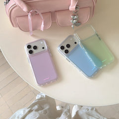 A variety of pastel color iPhone covers arranged on a white table next to a cute pink handbag.