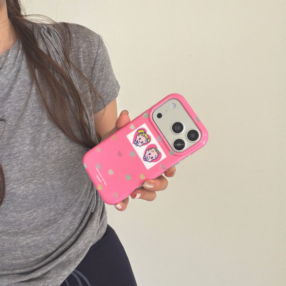 A hand holding a pink glitter heart phone case at a dynamic angle against a plain background.