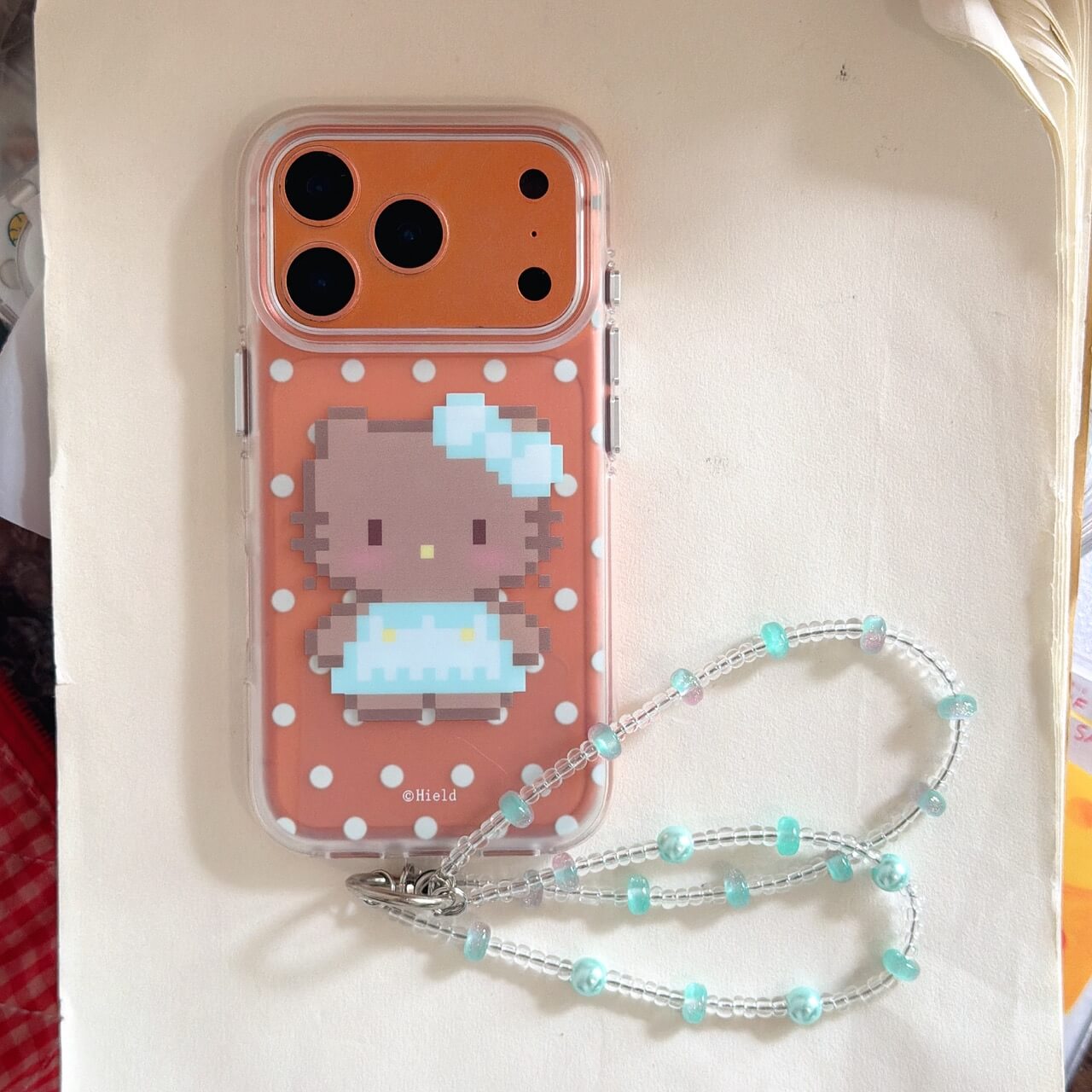Pixel kitty polka dot iPhone case with beaded wrist strap on white background
