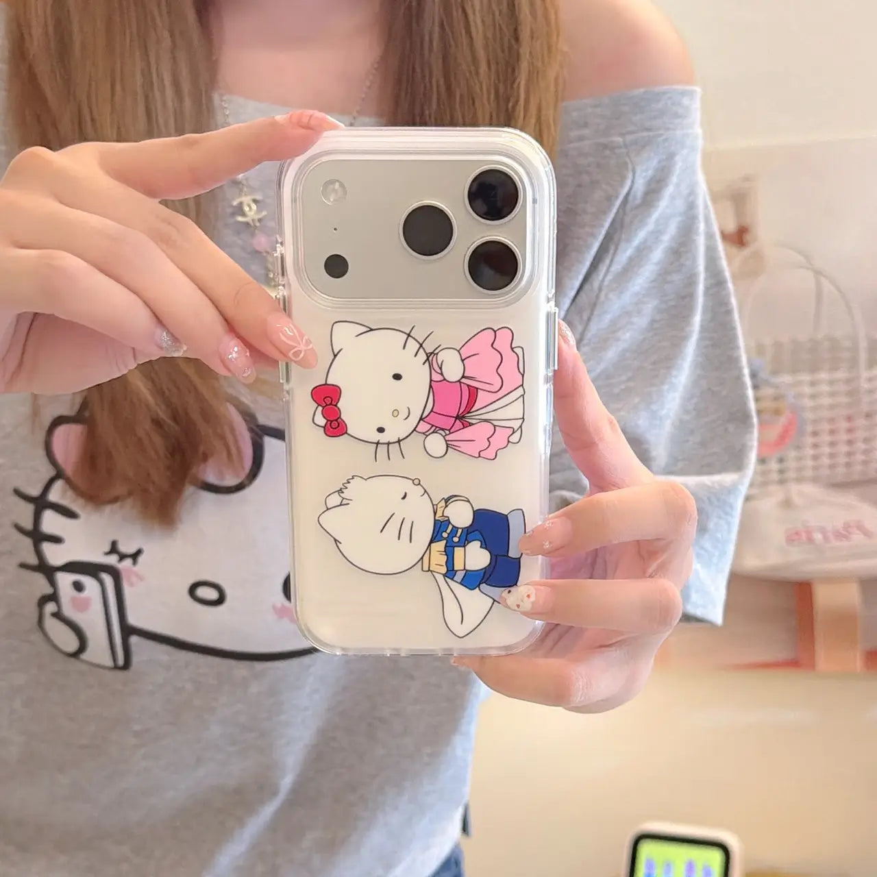 Close-up of a clear iPhone case with pink princess and blue prince kitty design