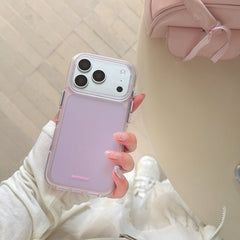 Top-down view of a hand holding a purple-pink aesthetic iPhone case over a white outfit lifestyle background.
