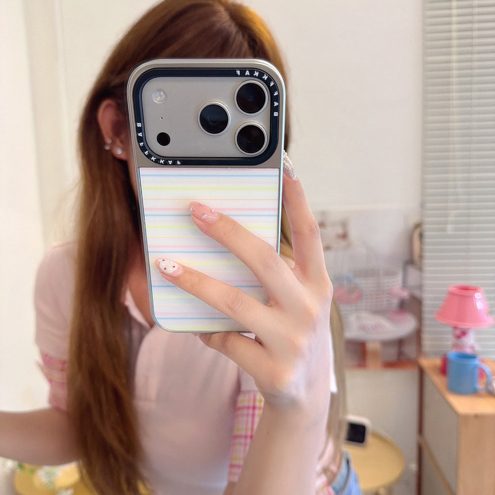A close-up mirror selfie showing a rainbow striped aesthetic phone cover on an iPhone.