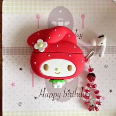 Flat lay of a red silicone My Melody earphone case and a shiny beaded strawberry keychain on a happy birthday card.