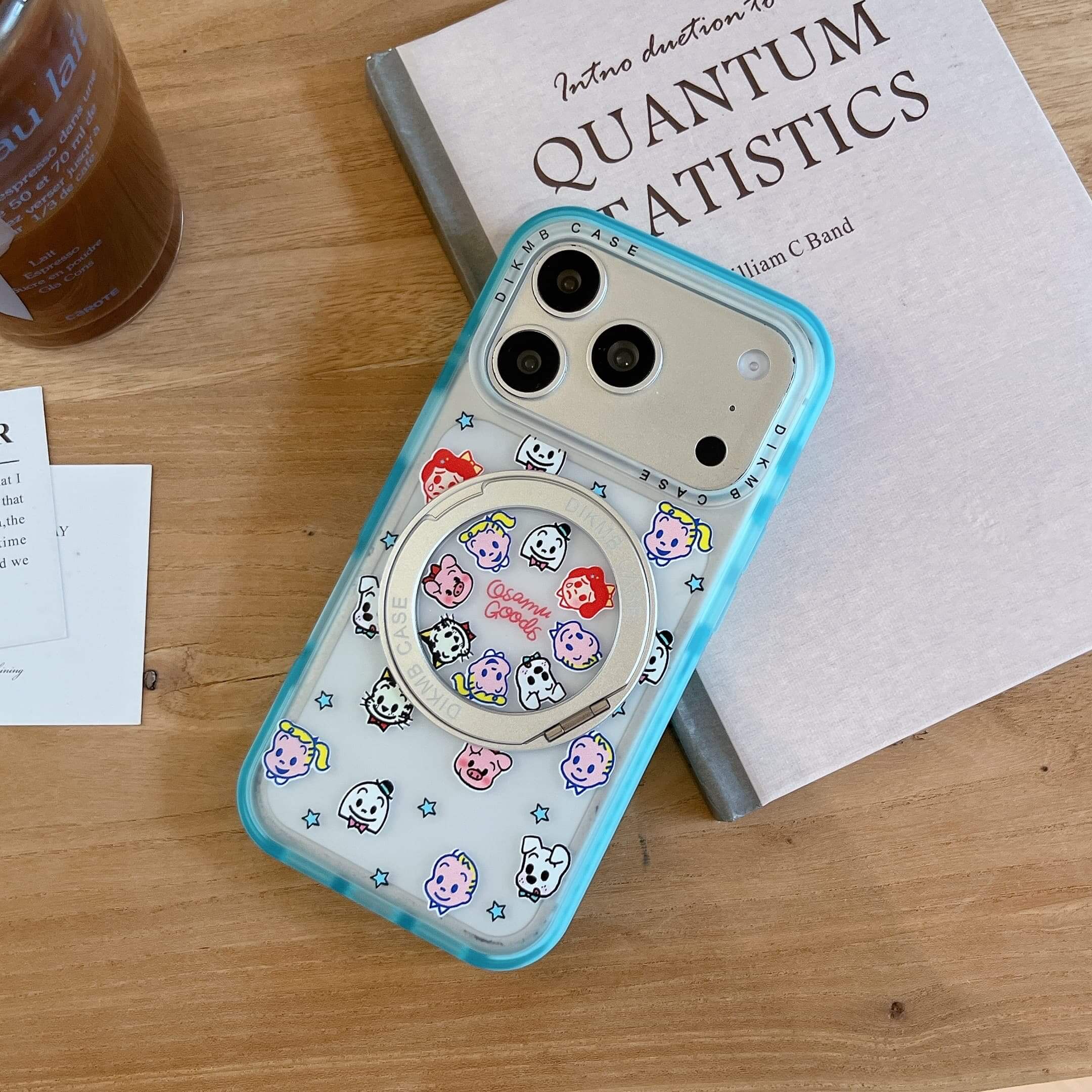 A retro cartoon clear iPhone case propped upright against a rustic stone on a white surface.