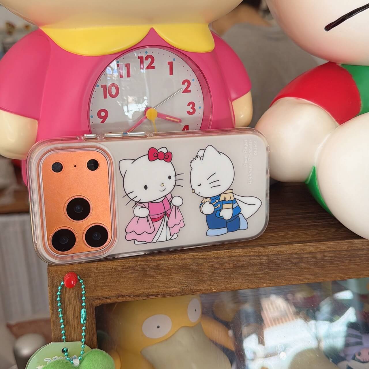 Royal kitty couple clear iPhone case displayed with colorful character décor