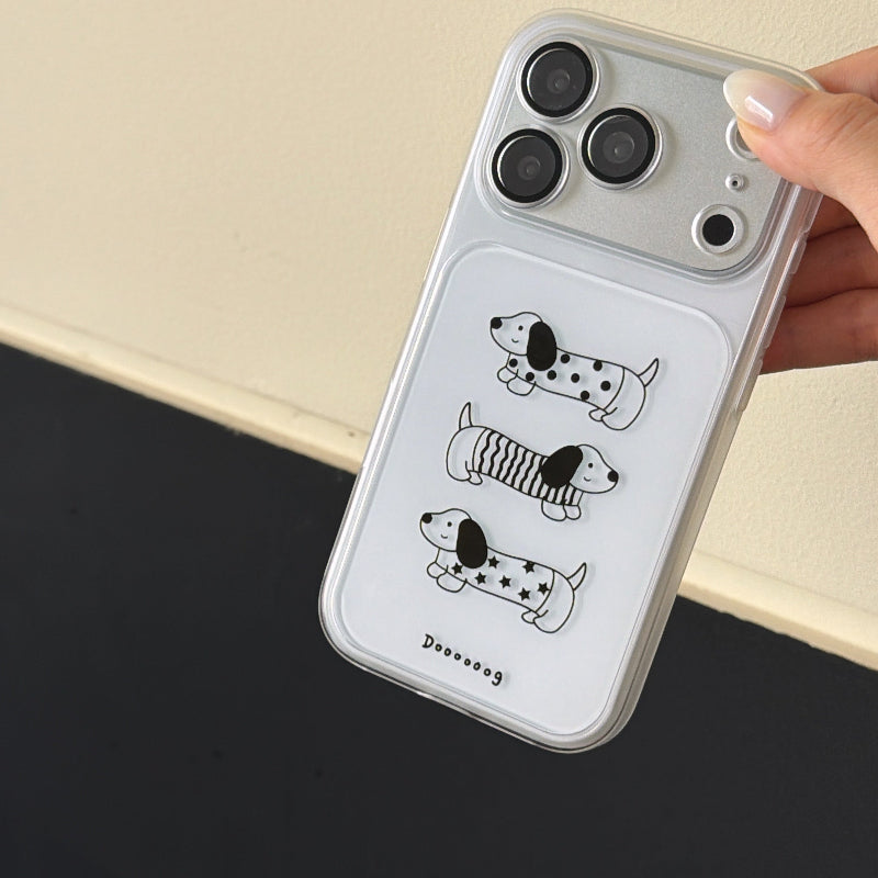 A close-up view of a shockproof dog graphic iPhone case showing the silver metallic camera frame border.