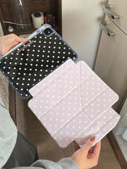 An open handheld view of a shockproof transparent back ipad folio demonstrating the detachment of the lavender polka dot front cover from the clear case.