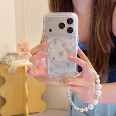 Close-up of a silver glitter galaxy iPhone case featuring a North Star design, metallic lens armor, and a chunky white pearl bead bracelet strap.