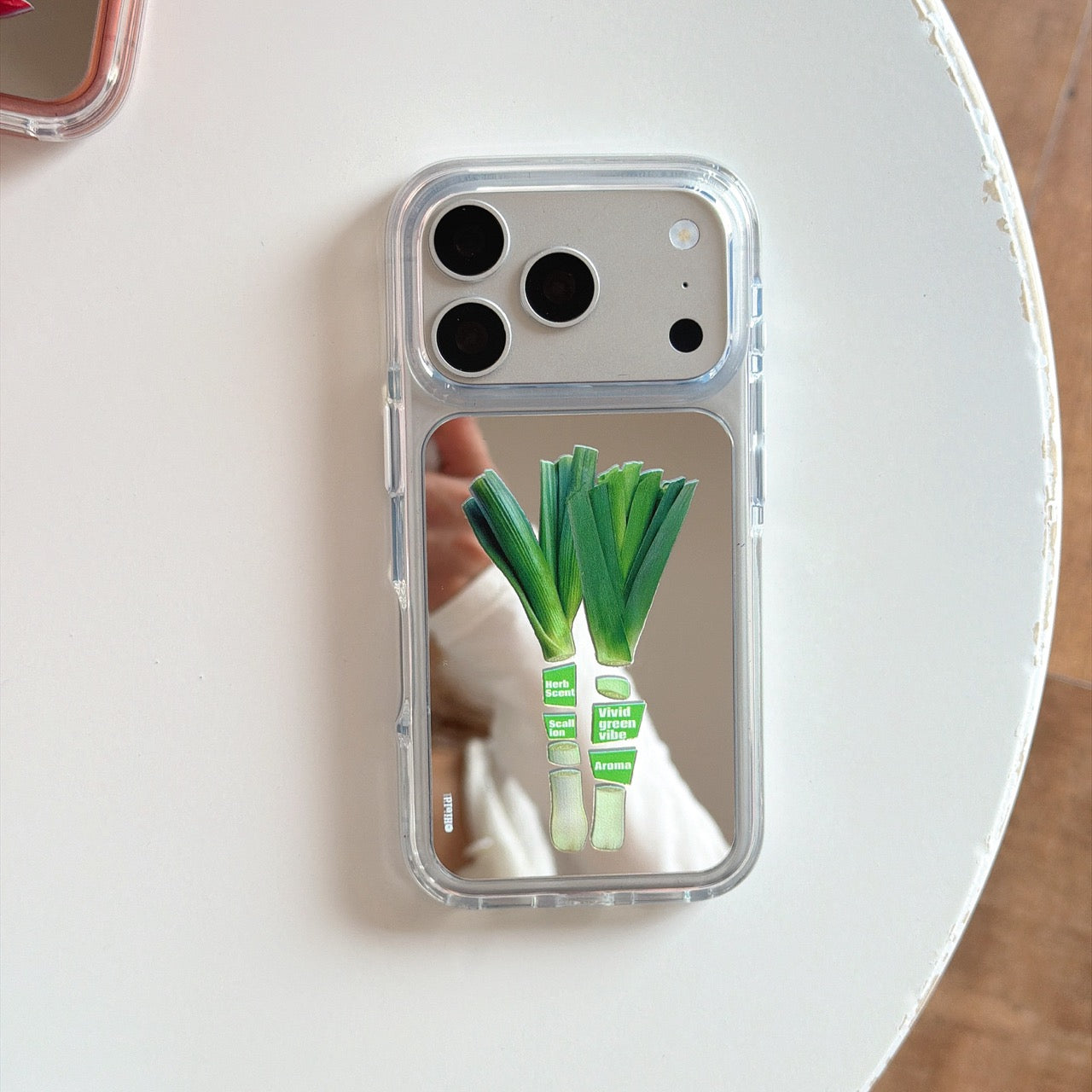 Product view of the silver scallion leek graphic mirror iPhone case showcasing the reflective back panel.
