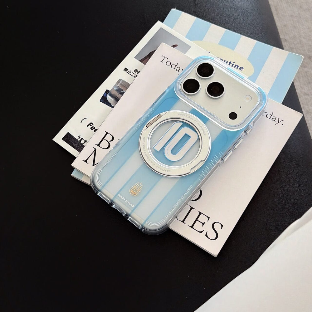 An Argentina sky blue soccer stripe iPhone case lying flat on magazines.