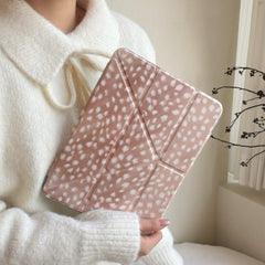 A person wearing a soft white knit sweater holding a soft girl aesthetic fawn print iPad folio cover close to their chest.