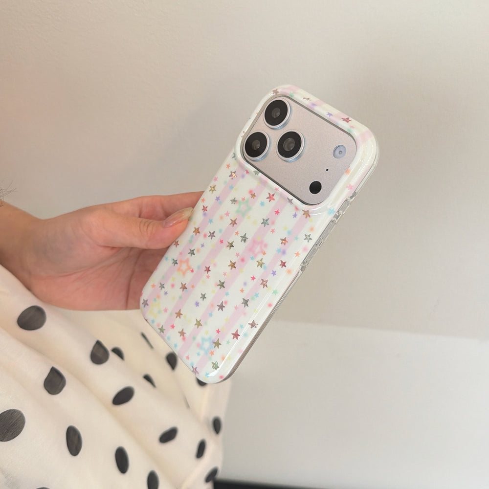 An angled shot of a starry fairy kei iPhone case being held against a plain white background.
