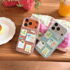 Mint green and orange sticker style iPhone covers displayed on a wooden table with a dessert plate and juice.
