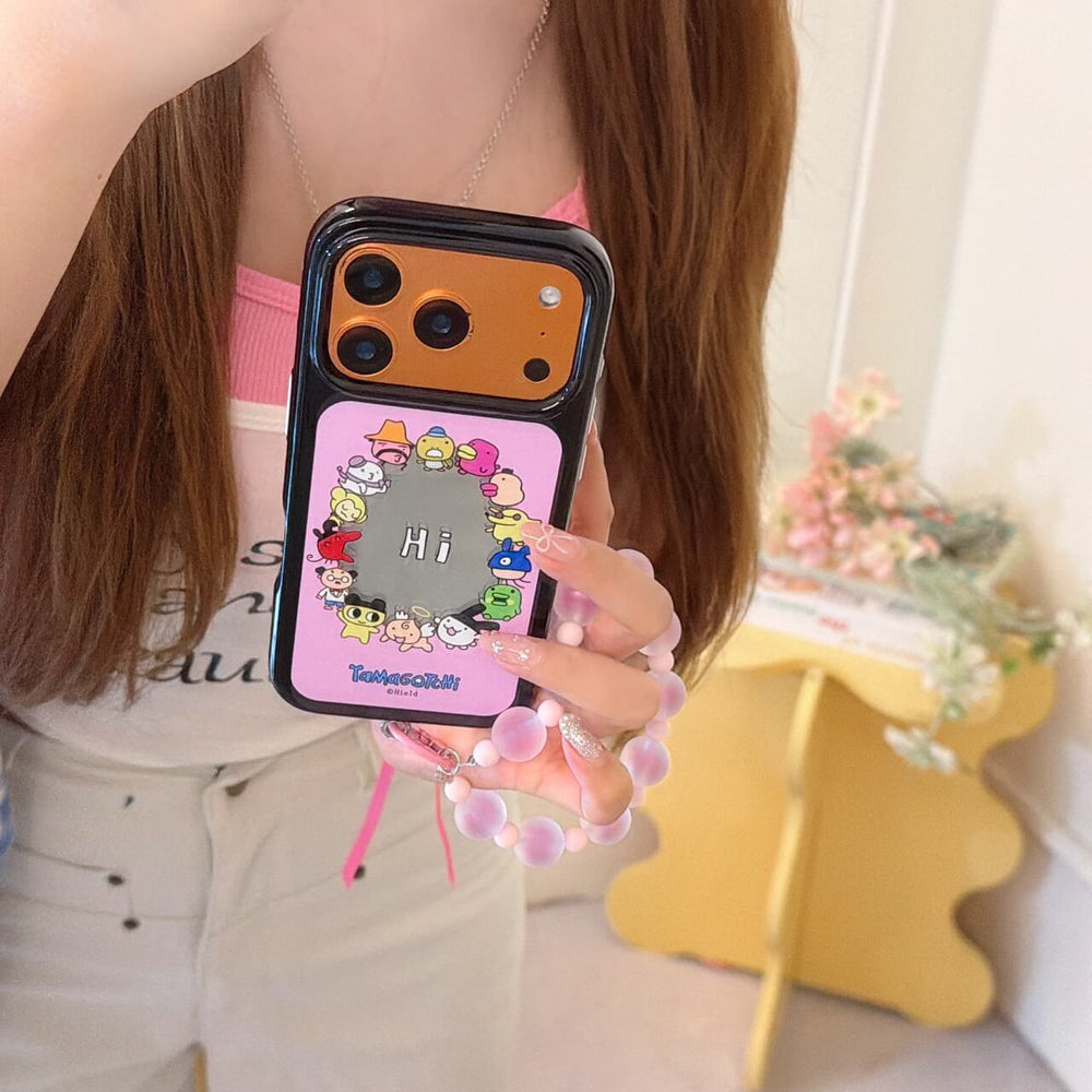 Close-up mirror selfie of the cute Tamagotchi phone case featuring a metallic orange camera section.