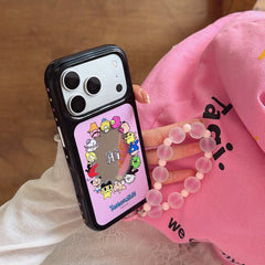 Hand holding the Tamagotchi cartoon mirror iPhone case with a pink frosted beaded wristlet charm.