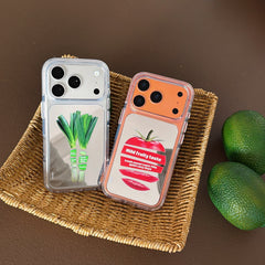 Tomato and green scallion mirror phone cases displayed neatly inside a woven rattan basket with fresh limes.