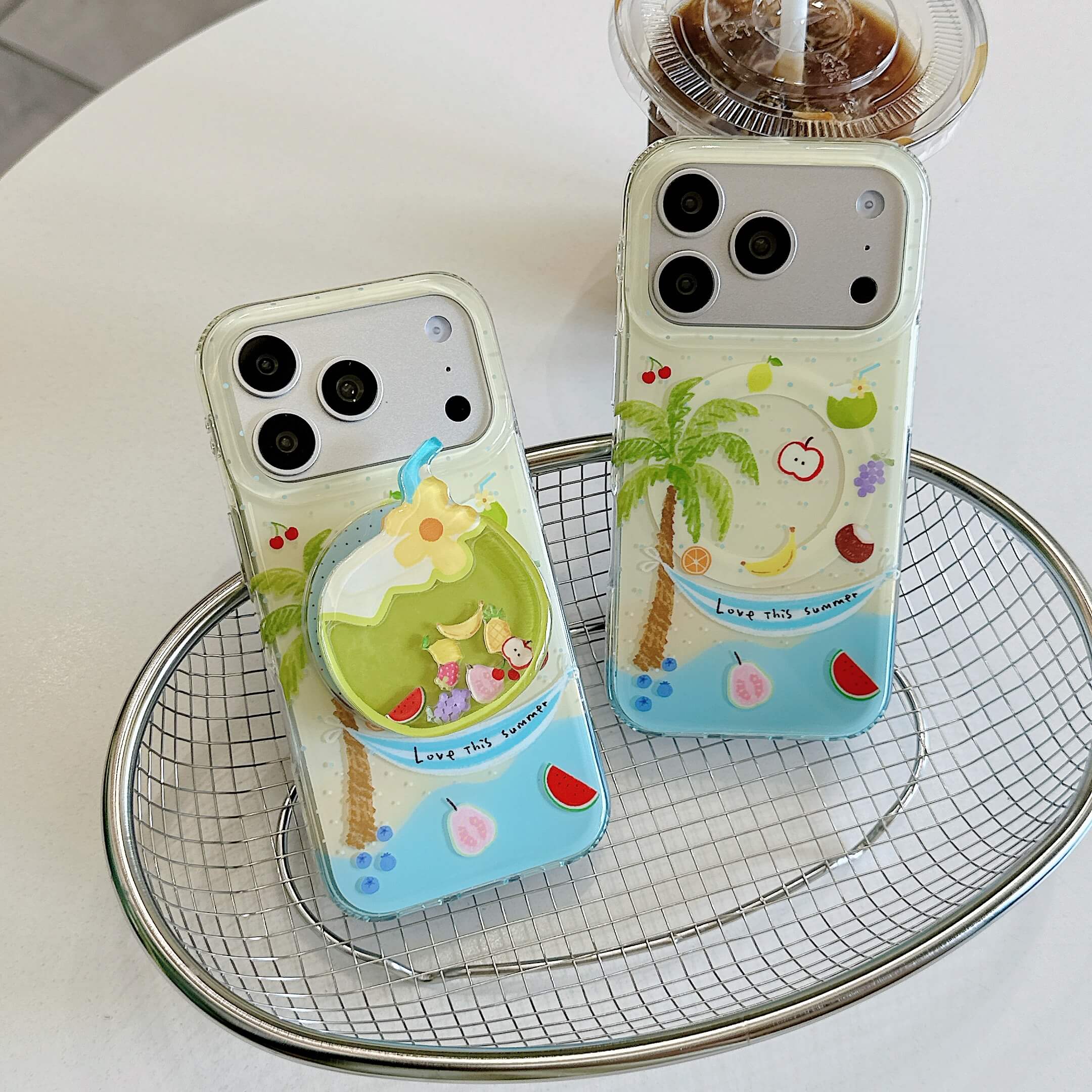 Two tropical summer iPhone cases displayed with fruit and palm tree prints.