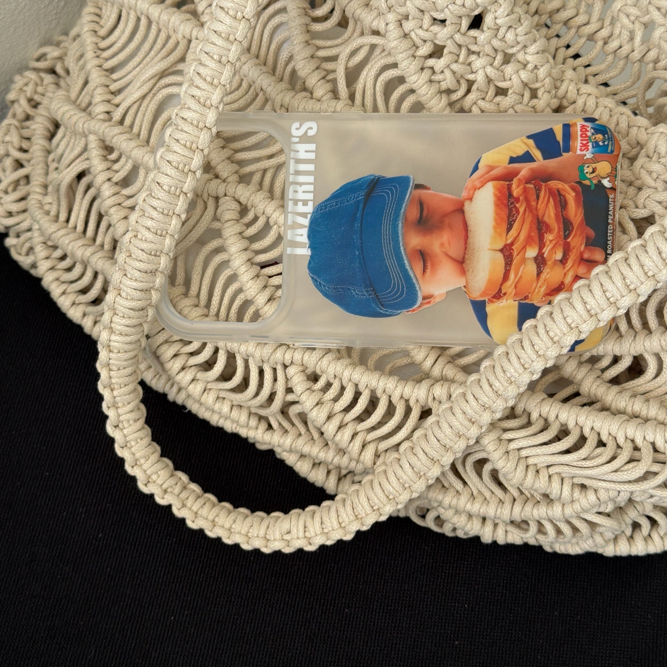 A vintage boy sandwich iPhone case tucked inside a cream macrame woven bag.