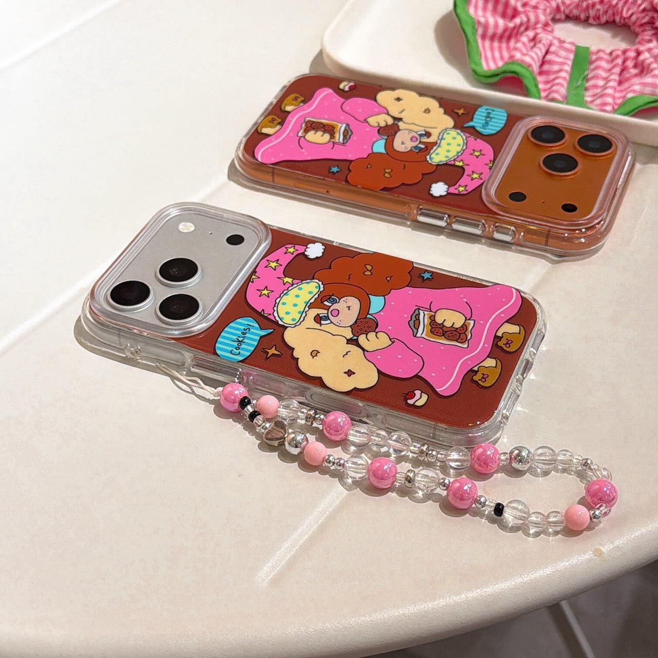 Two Y2K aesthetic cartoon dog phone cases in silver and orange metallic frames lying flat on a white table.
