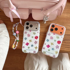 Two Y2K dopamine flower phone cases in silver and orange frames next to a pink aesthetic handbag.