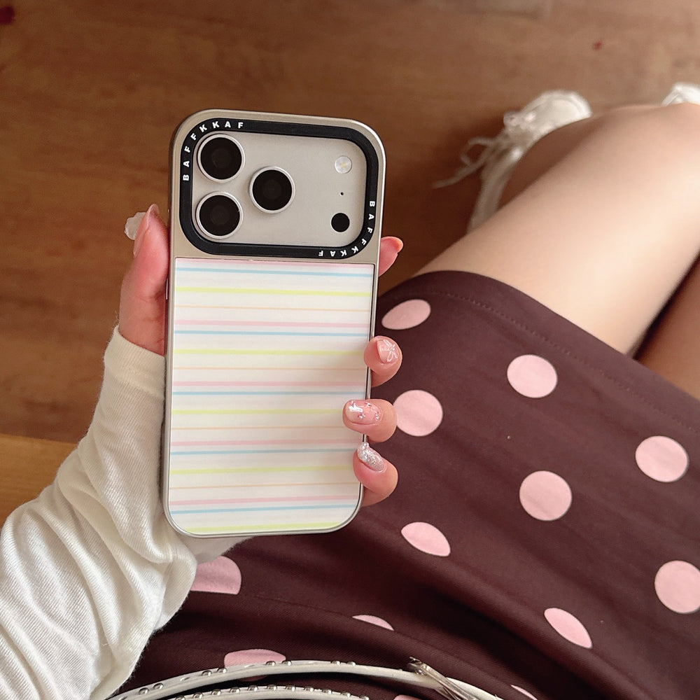 A girl holding a Y2K style pastel horizontal stripe phone shell against a brown polka dot dress.