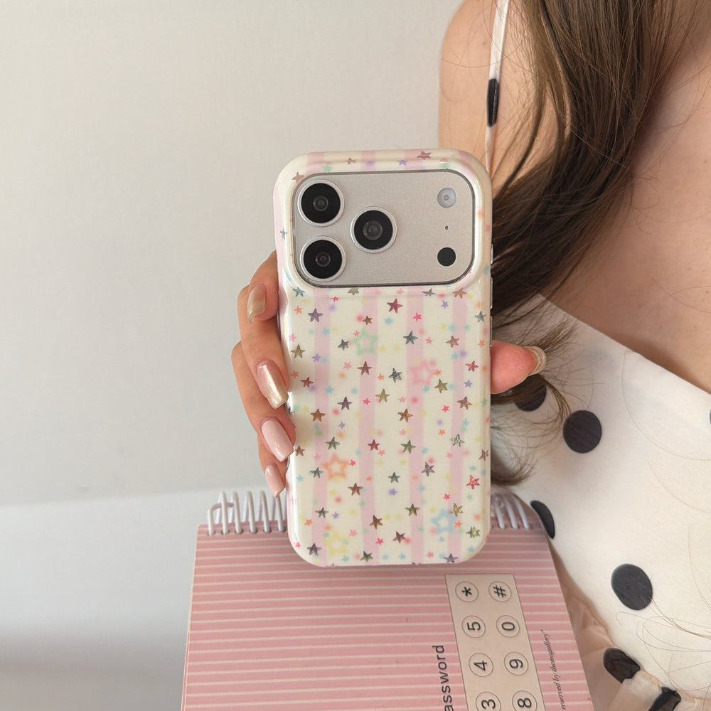 A close-up of a y2k pink striped star iPhone case held in front of a pink spiral notebook.