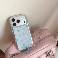 A Y2K clear case with sparkling blue stars leaning on a pastel pink handbag.